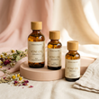 Set of V-Spot Yoni Oil bottles in 1oz and 2oz sizes on a soft blush pink background